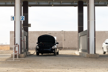 The car is refueled with gas on the street. Gas station for methane. - obrazy, fototapety, plakaty