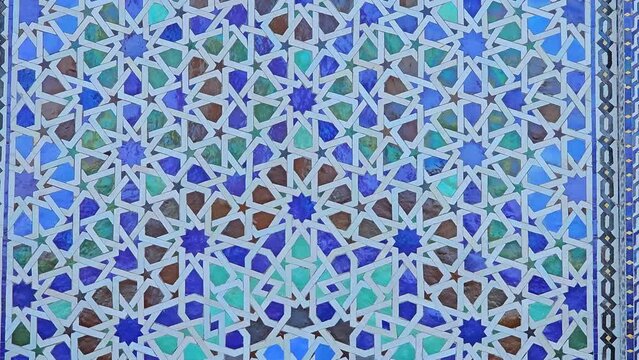 pan shot on Moroccan Colorful zellige tiles pattern at the Mohammed V mausoleum in Rabat Morocco . Mosaic pattern, traditional Islamic geometric design. Moroccan craft, handmade.
