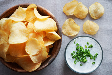 Potato chips with sauce with herbs on a gray background
