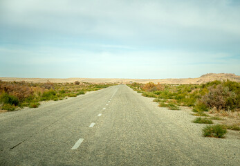old asphalt road in the middle of the desert in the Kyzylkum desert.