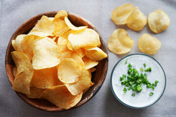 Potato chips with sauce with herbs on a gray background