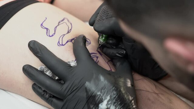 Plano detalle de tatuador realizando tatuaje