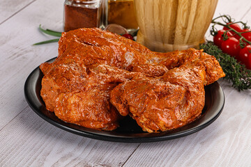 Raw turkey shoulder wing in Indian tandoori marinade