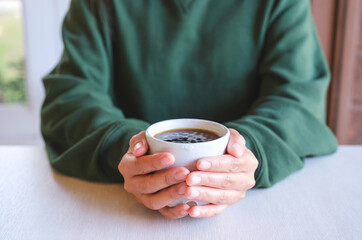 Closeup image of a woman holding a cup of hot coffee