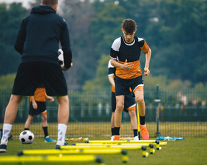 Boys' Soccer Practice Camp. Teenage boys in football training with a young coach. Teenagers on...