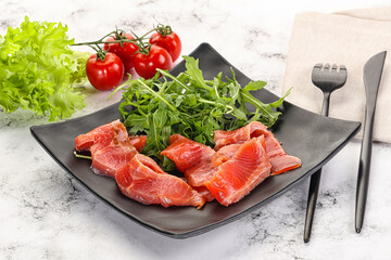 Sliced salmon with fresh arugula