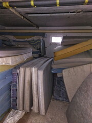 Messy basement room full of dirty matresses - 712234550