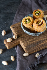 Obraz na płótnie Canvas Traditional arabic dessert baklava with pistachios. Dark background