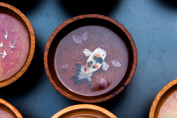 Fishes are painted in wooden bowls