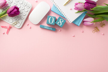 March 8th Desk: Capturing essence of Women's Day at the office – a top view of desk arrangement with a keyboard, mouse, cube calendar, trendy notepads, gold pen, binder clips, hearts and lilac tulips