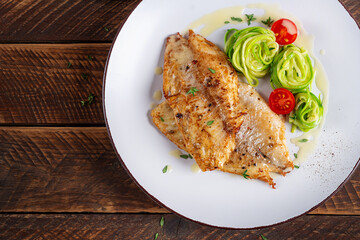 Grilled fish fillet with zucchini pasta. Healthy food concept. Top view, flat lay