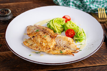 Grilled fish fillet with zucchini pasta. Healthy food concept.
