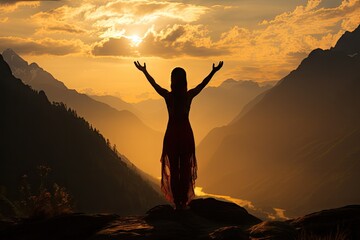 A woman doing meditation and yoga exercises at sunset on a mountain top