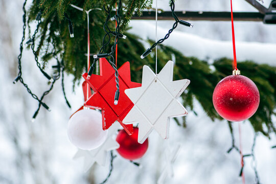 Christmas decorations hanging from a tree in a street food market, Christmas baubles and stars with lights