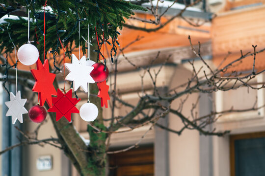 Christmas decorations hanging from a tree in a street food market, Christmas baubles and stars with lights