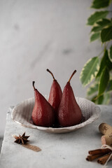 Poached pears in spicy red wine syrup, selective focus. Traditional dessert pears stewed in red...