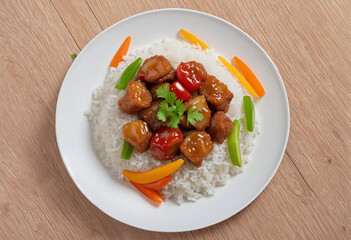 Sweet and Sour Pork with Vegetables - A delicious dish featuring fried pork chunks with a tangy sweet and sour sauce, served over rice with fresh vegetables.