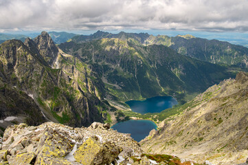 Fototapeta na wymiar View from the mountain Rysy of Morskie Oko, Czarny Staw lakes. High Tatras. Border of Poland and Slovakia. Hiking and climbing Slovakia. Landscape of mountain tops and the lake between them.