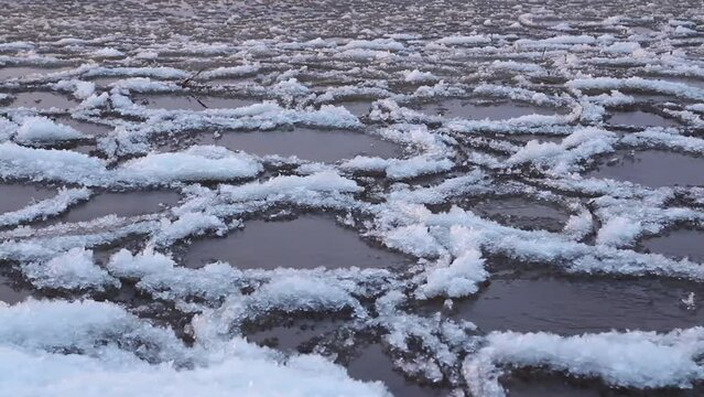 ice and white slush swaying on the surface of the lake, winter landscape