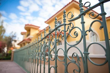 Foto op Canvas elegant wrought iron fence surrounding a spanish style villa © primopiano