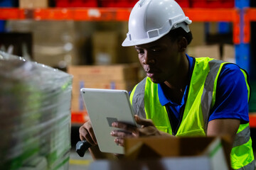 Male american african factory company employee scanning box checking number of products on goods shelves with tablet in warehouse. Man working in logistics and distribution. Import-export warehouse.
