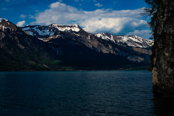 Obraz premium Scenic view of a lake surrounded by the Alps in Switzerland, covered by snow