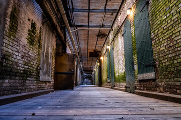 Corridor in an old, abandoned jail with brick walls