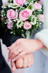 Obraz na płótnie Canvas Wedding concept. Close-up of bridal and groom hands with a golden rings on it.