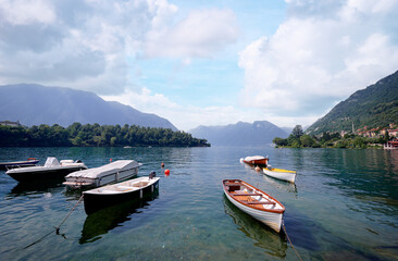 Fototapeta na wymiar Beautiful scene of boats on lake Como in Italy. A big blue lake surrounded by green hills
