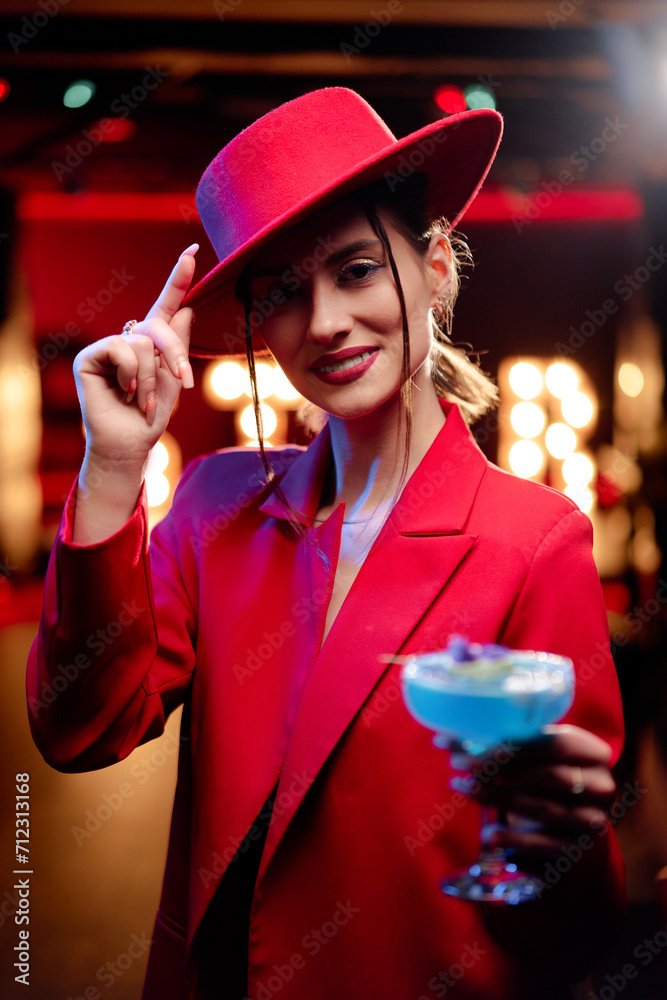 Wall mural Party and celebration. Happy smiling young woman drinking cocktail having fun at the night club