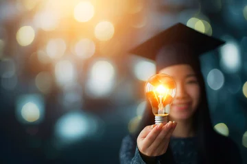 Foto op Plexiglas Education, e-learning graduate certificate and business concept, Women showing light bulb with graduation hat in hand Education technology study knowledge, human creative thinking idea © Enrique