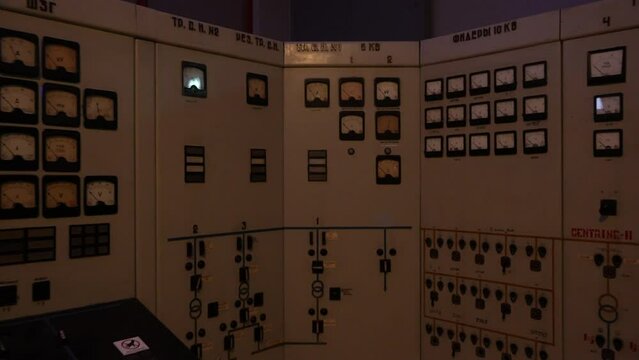 Moving back camera shot of soviet console room. Red warning light informing about dangerous situation.
