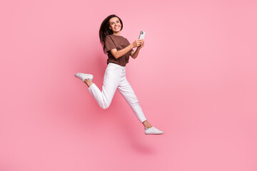 Fototapeta na wymiar Full length photo of beautiful young business woman influencer working with smartphone run in air isolated on pink color background