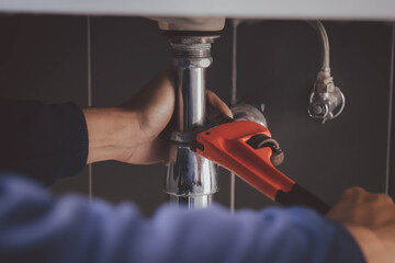 plumber at work in a bathroom, plumbing repair service , fix water plumbing leaks, replace the...