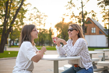 Mother and daughter drinking coffee in evening