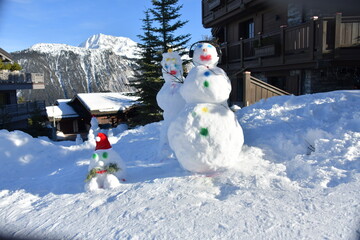 snowman family in a ski resort by winter