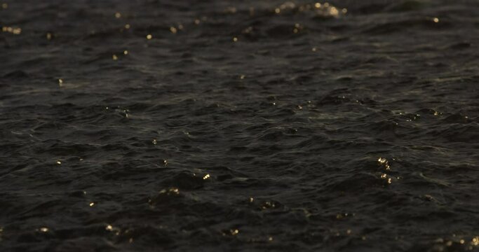 golden reflections on a calm flowing river stream at sunset