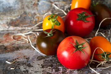 Mix from red, yellow and green tomatoes. Italian Cuisine. Dark background