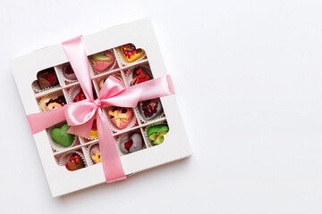Box with sweet chocolate candies on color background, Various candy sweets. Valentines day gift box. Top view flat lay with copy space