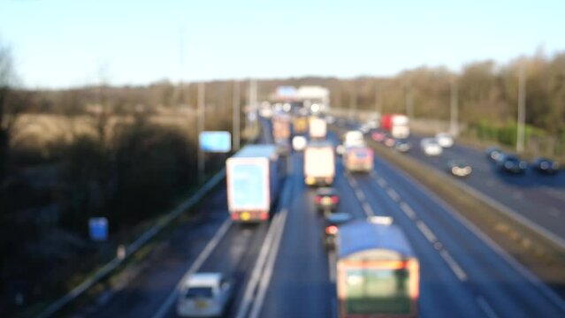 Blurry, defocussed high angle view of heavy highway traffic flow in England in autumn, backgrounds.