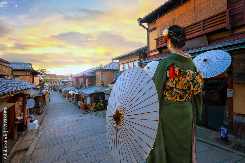 Poster Scenic sunset of Nineizaka or Ninenzaka, ancient pedestrian road in Kyoto, Japan with a young Japanese woman in a traditional Kimono dress