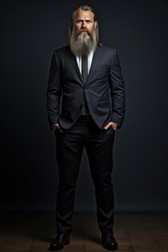 Portrait of a serious, confident middle-aged businessman with a beard in a suit on a black background