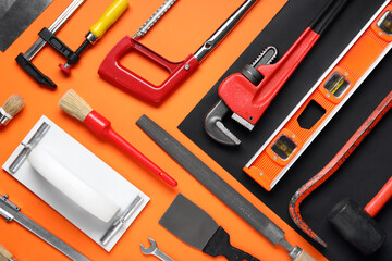 Set of construction tools on orange background