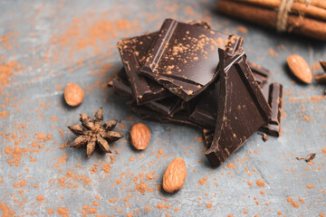 Heap of delicious dark chocolate pieces or cubes, chopped, broken chocolate bar, almond nut,...
