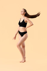 Naklejka premium Beautiful woman in underwear on beige background