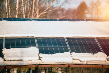 Solar panels are covered with snow in winter. Photovoltaic electricity installation during the...
