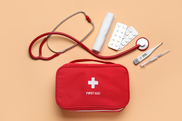 First aid kit and pills on beige background