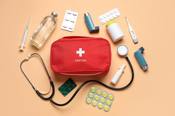 First aid kit and pills on beige background