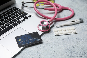 Laptop, credit card and items from first aid kit on grunge white background