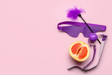 Sex toys and half of tasty grapefruit on pink background